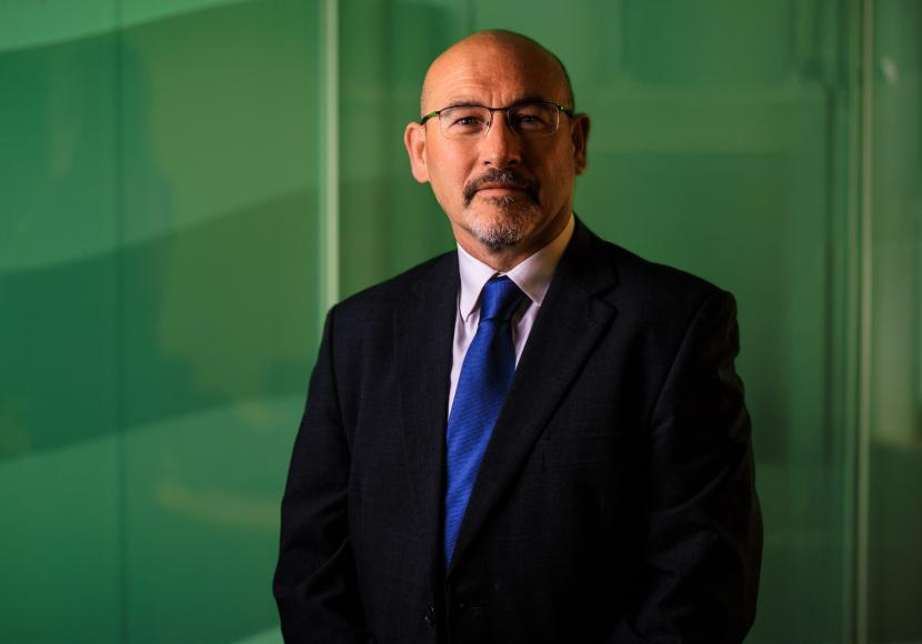 A professional headshot of John Curran